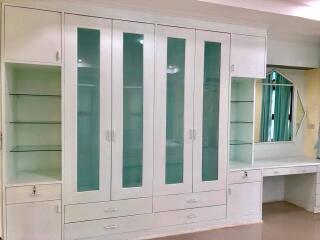 built-in wardrobe with glass panels and a desk