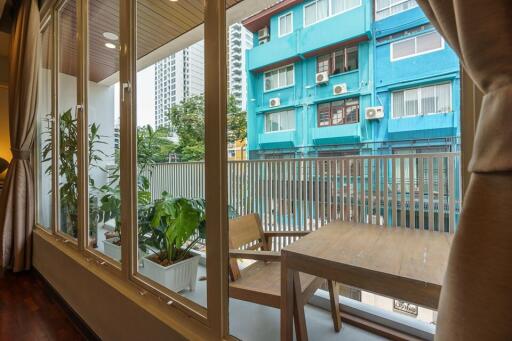 Balcony view with sitting area and adjacent buildings