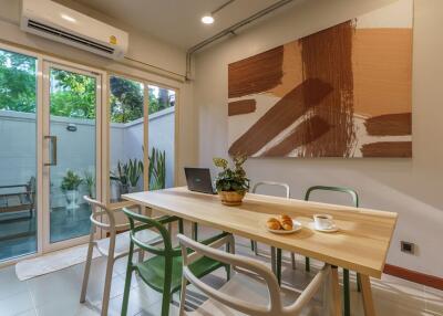 Dining area with sliding glass doors, modern art, and air conditioning.