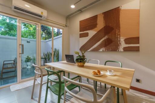 Dining area with sliding glass doors, modern art, and air conditioning.