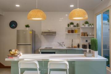 Modern kitchen with counter seating and stainless steel appliances