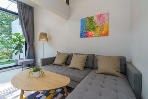 Modern living room with grey couch and colorful artwork