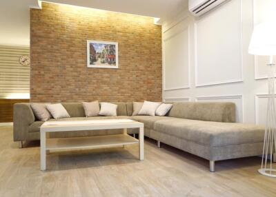 Modern living room with brick accent wall and L-shaped sofa