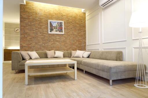 Modern living room with brick accent wall and L-shaped sofa