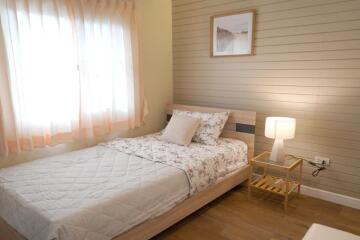 Cozy bedroom with a window, bed, and nightstand