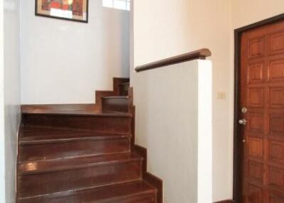 Hallway with wooden stairs and wall art