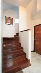 Hallway with wooden stairs and wall art