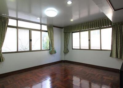 Bright bedroom with parquet flooring and large windows