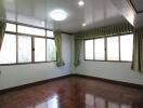 Bright bedroom with parquet flooring and large windows