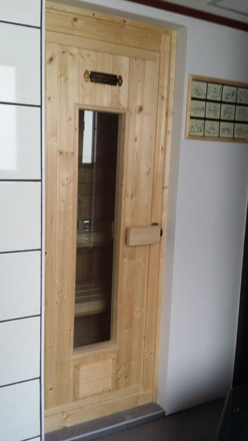 Wooden sauna room door with glass window