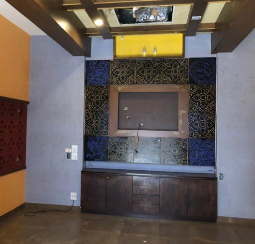 Unfurnished living room with decorative wall panel, built-in storage and wall-mounted plug points