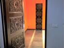 Ornate door at entrance with a view of a small hallway