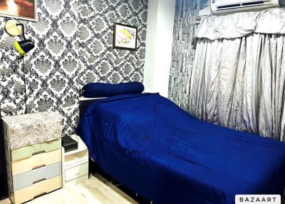 Bedroom with bed, patterned wallpaper, and air conditioning.