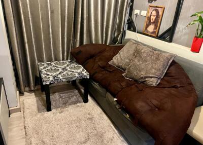 Cozy living room with brown sofa, patterned coffee table, and artwork