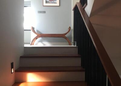 Indoor staircase leading to a landing area with a decorative bench and framed artwork