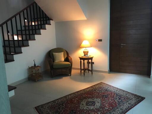 Cozy corner in a living area with a chair, lamp, and rug