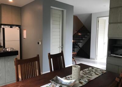 Modern dining area with table, chairs, and view of kitchen