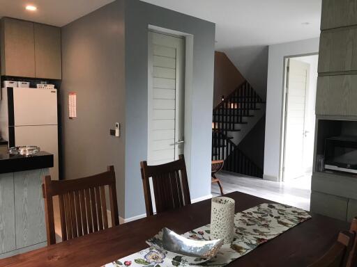 Modern dining area with table, chairs, and view of kitchen