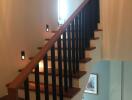 Wooden staircase with railing in a well-lit hallway