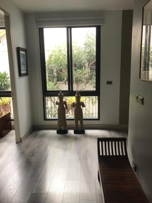 Room with window view and sculptures