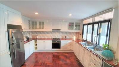 Modern kitchen with stainless steel appliances, wooden flooring, and ample natural light