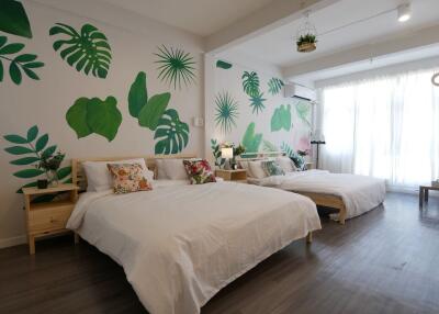 Spacious bedroom with two beds and botanical wall art