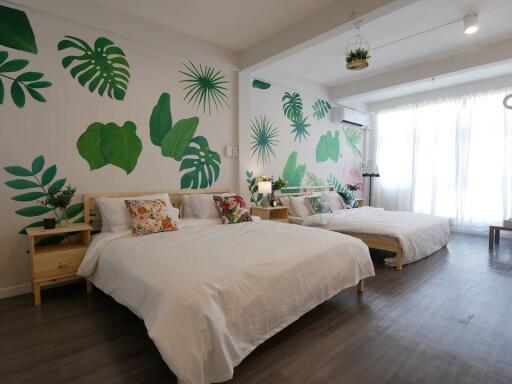 Spacious bedroom with two beds and botanical wall art