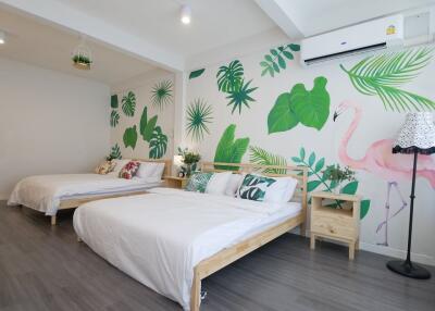 Modern bedroom with two beds, wall mural, and air conditioning