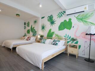 Modern bedroom with two beds, wall mural, and air conditioning