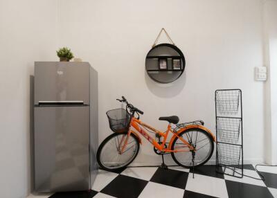 Utility area with refrigerator, bicycle and shelving unit