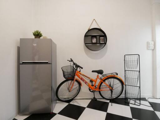 Utility area with refrigerator, bicycle and shelving unit