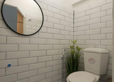 Modern bathroom with tiled walls and round mirror