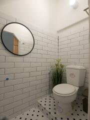 Modern bathroom with tiled walls and round mirror