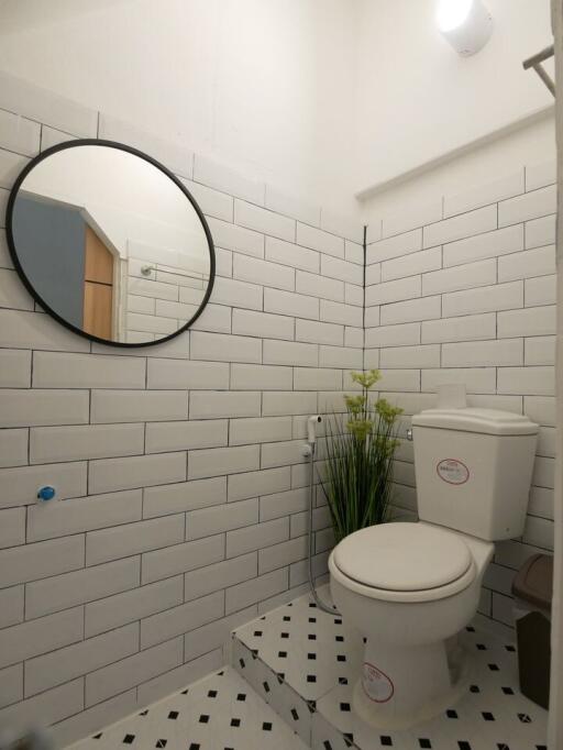 Modern bathroom with tiled walls and round mirror