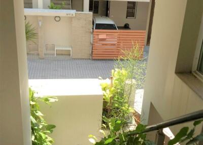 View of an apartment building entrance with plants and railing