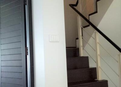 Indoor staircase with dark wooden steps and white railing