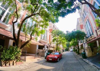 Street view of residential buildings with cars parked