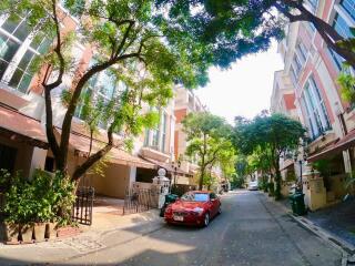 Street view of residential buildings with cars parked