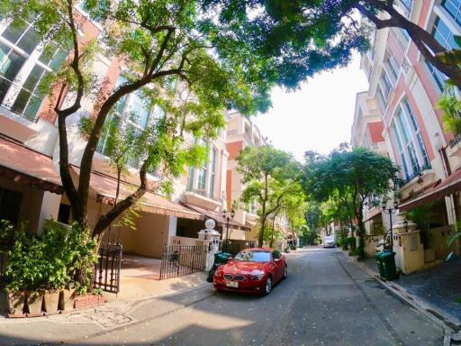 Street view of residential buildings with cars parked