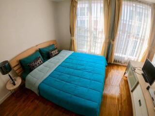 Bedroom with blue bedding and large windows