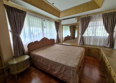 Spacious bedroom with a large bed and ample natural light from multiple windows.