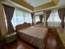 Spacious bedroom with a large bed and ample natural light from multiple windows.