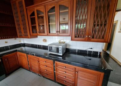 Spacious kitchen with wooden cabinets and black marble countertops