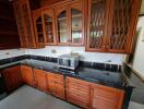 Spacious kitchen with wooden cabinets and black marble countertops