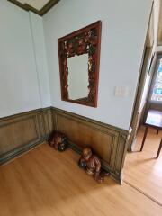 Decorative hallway with mirror and wooden sculptures