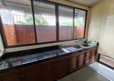 Spacious kitchen with countertop, sink, and large windows