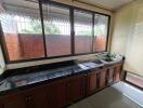 Spacious kitchen with countertop, sink, and large windows