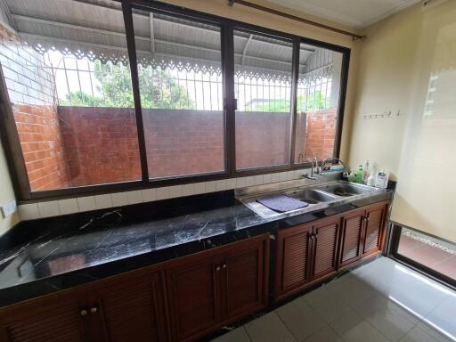 Spacious kitchen with countertop, sink, and large windows