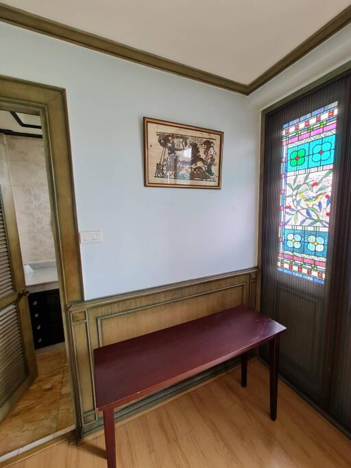 Small room with a table near a stained glass window