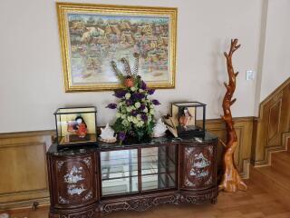 Living room area with decorative cabinet and framed artwork